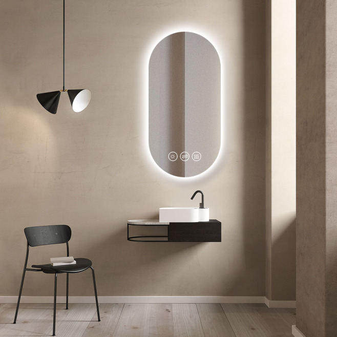 Badrum beige vägg svart stol svart lampa oval badrumsspegel med ljus